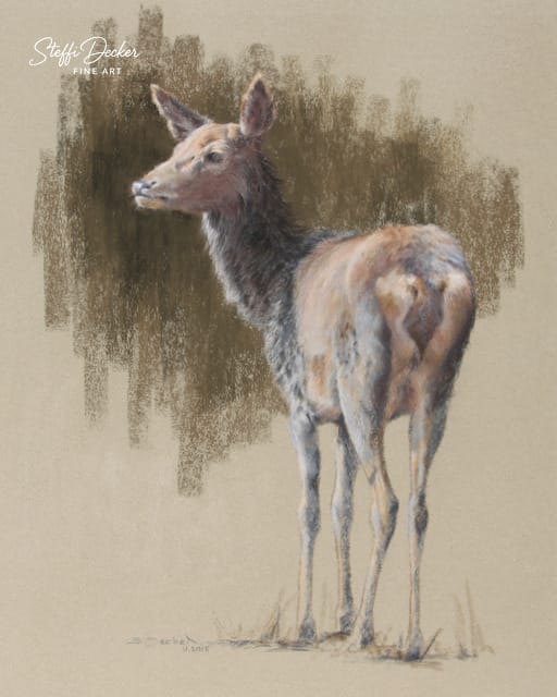 Ein schlankes Reh mit hellem, leicht rötlichem Fell steht seitlich auf einer Wiese, vor einem weich gemalten, naturfarbenen Hintergrund.