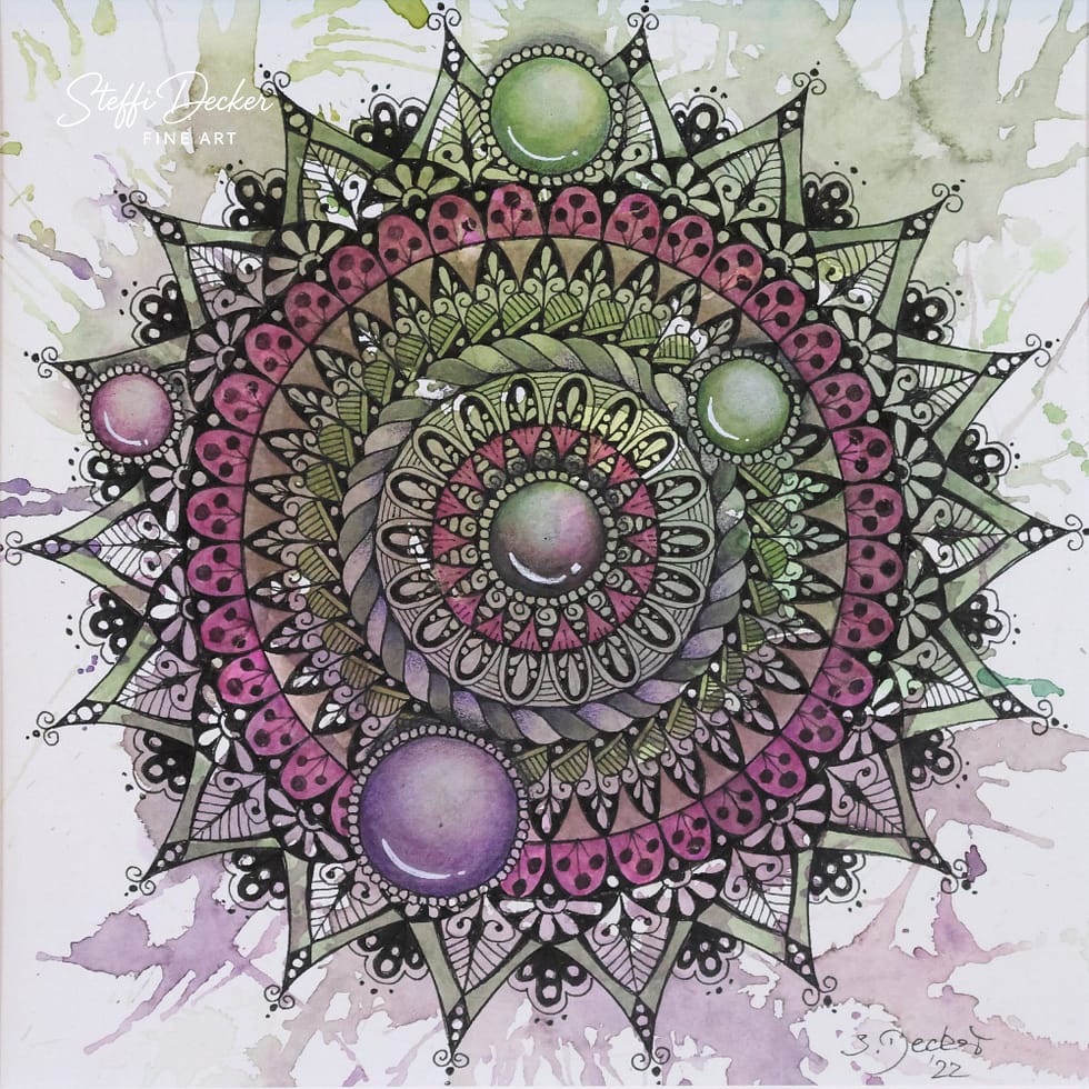 Ein detailreiches Mandala mit mehreren konzentrischen Ringen aus floralen und geometrischen Mustern in Pink‑, Grün‑ und Violetttönen; vier perlmuttartig schimmernde Kreise sitzen auf dem äußeren Ring, während der Hintergrund aus aquarellartigen Spritzern in Grün und Lila besteht.